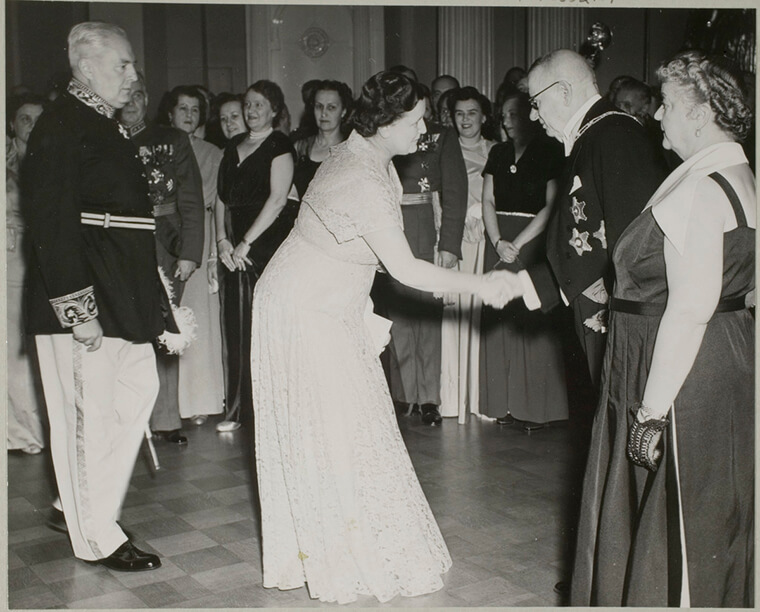 Nainen tervehtii presidentti Paasikiveä ja hänen vaimoaan Linnan Juhlissa itsenäisyyspäivänä vuonna 1950.