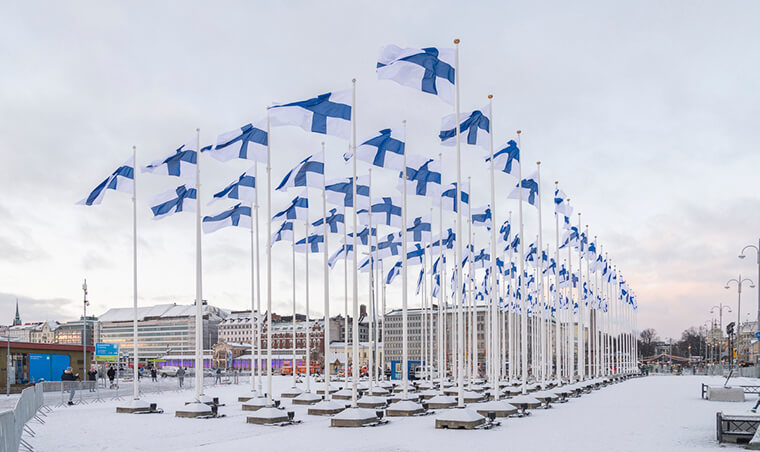Useita Suomen lippuja nostettu salkoon Helsingin Kauppatorilla Suomi100-juhlavuoden kunniaksi.